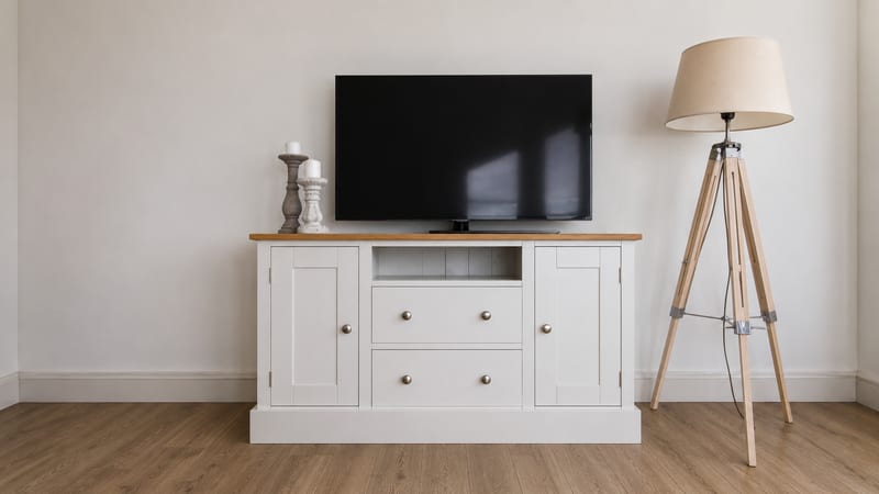White painted 4ft TV cabinet with a solid oak top, two drawers and an open media shelf between two cupboard doors, with a television and candlesticks on top