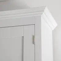 Detail of the top corner of the Welsh dresser, showing the stepped white cornice moulding and a brass butt hinge set into the panelled door