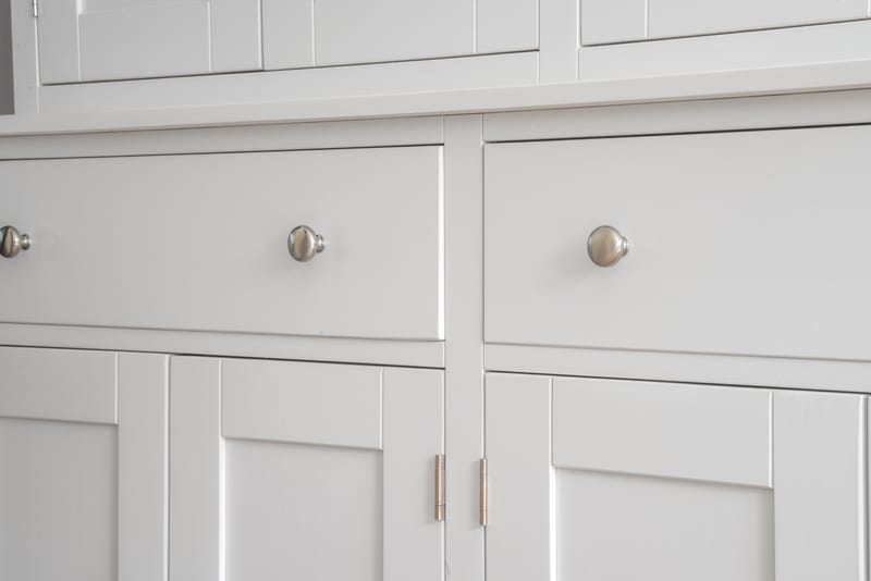 Close view of the painted dresser base, showing the two drawer fronts with brushed nickel knobs above recessed Shaker panelled cupboard doors
