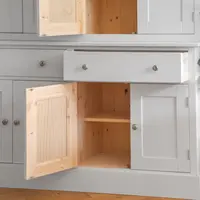 The Radwell dresser with an upper door, a base cupboard door and a drawer all standing open, revealing the natural solid pine interiors, an adjustable shelf and tongue-and-groove pine back panels behind the grey painted carcass