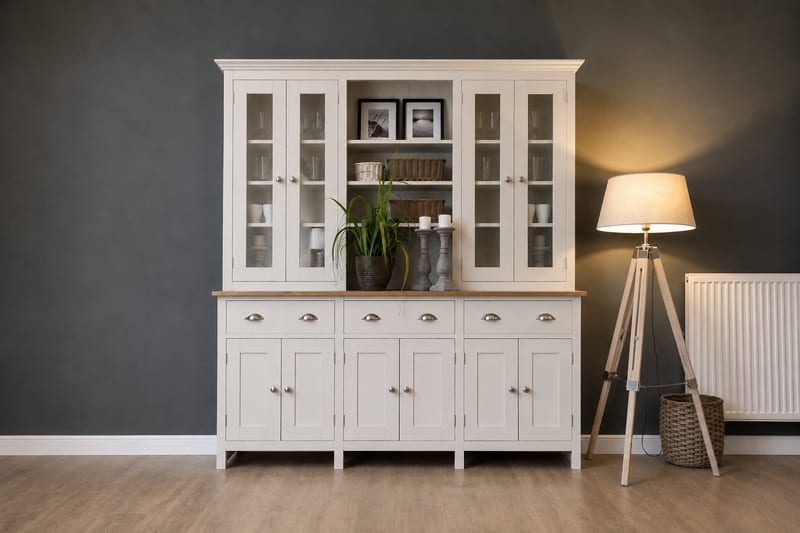 Cream painted 6ft Welsh dresser with glazed doors either side of an open shelf holding framed prints, above an oak worktop with three cup handled drawers and six cupboard doors