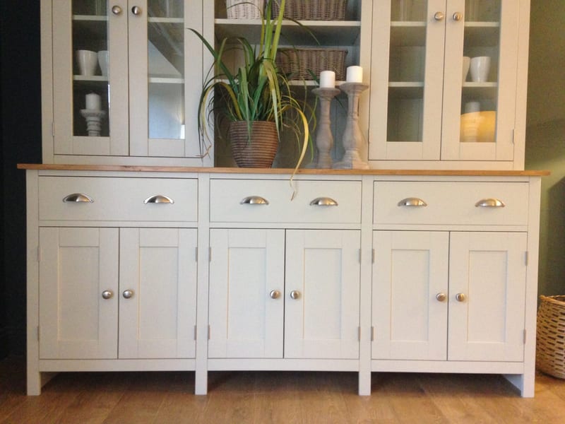 Close view of the dresser base, showing the waxed pine top, three drawers with brushed nickel cup handles, six shaker doors with round knobs and the glazed rack starting above