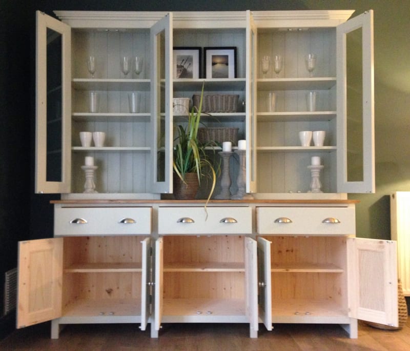 Front view of the dresser with every door open, showing glassware on the pale blue lined rack shelves and the bare pine cupboard interiors, each with a single shelf, in the base