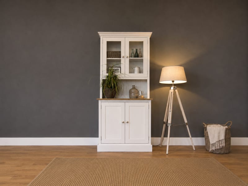 Compact cream painted 3ft Welsh dresser with two glazed upper doors above an oak worktop and two cupboard doors, against a dark grey wall beside a tripod floor lamp