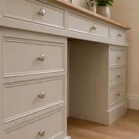Angled detail from the left of the desk, looking along the frieze drawers to the open kneehole, the right hand pedestal drawers and the stepped plinth on a wood plank floor