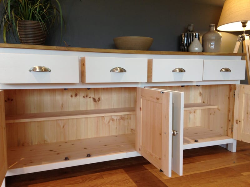 Front view of the sideboard with its cupboard doors open, showing the bare pine interior and door backs, tongue-and-groove boards, a shelf in each bay and the white drawer fronts above