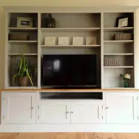 Pale grey 7ft TV media dresser with a solid oak worktop, open shelving either side of a television, cupboards below, styled with baskets, a plant and framed prints