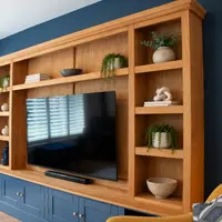Side view along the length of the oak top section and navy base cupboards, with a mustard armchair in the foreground
