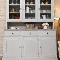Full front view of the grey painted dresser with three glazed upper doors, an open display shelf, three drawers and three cupboard doors below a light oak top with brushed nickel knobs
