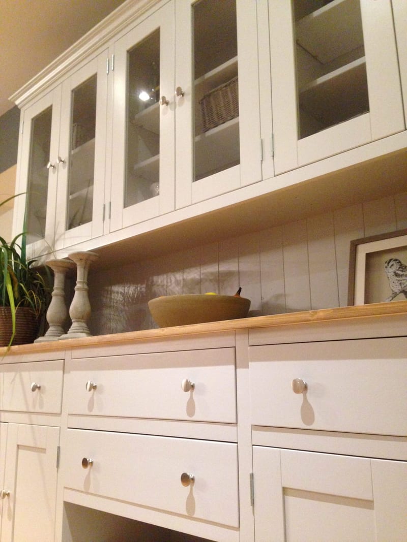 Upward view of the glazed top standing on the base, showing tongue-and-groove backing, two turned candlesticks and a stoneware bowl on the timber top with drawers below