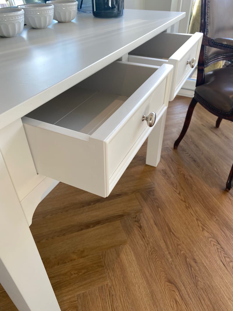 Both drawers pulled open on the painted dressing table, showing the grey painted interiors with boarded bases, the chrome knobs and the shaped brackets under the apron