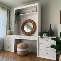 White painted Colmworth modular dressing table with a canopy shelf above a round rattan mirror, flanked by two three drawer chests, with a jute pouffe tucked underneath