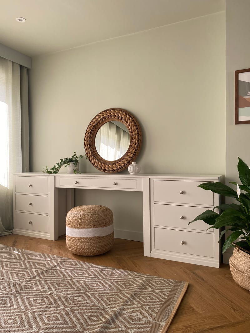 White painted Colmworth dressing table with a single drawer between two three drawer chests, beneath a round rattan mirror with a jute pouffe tucked underneath