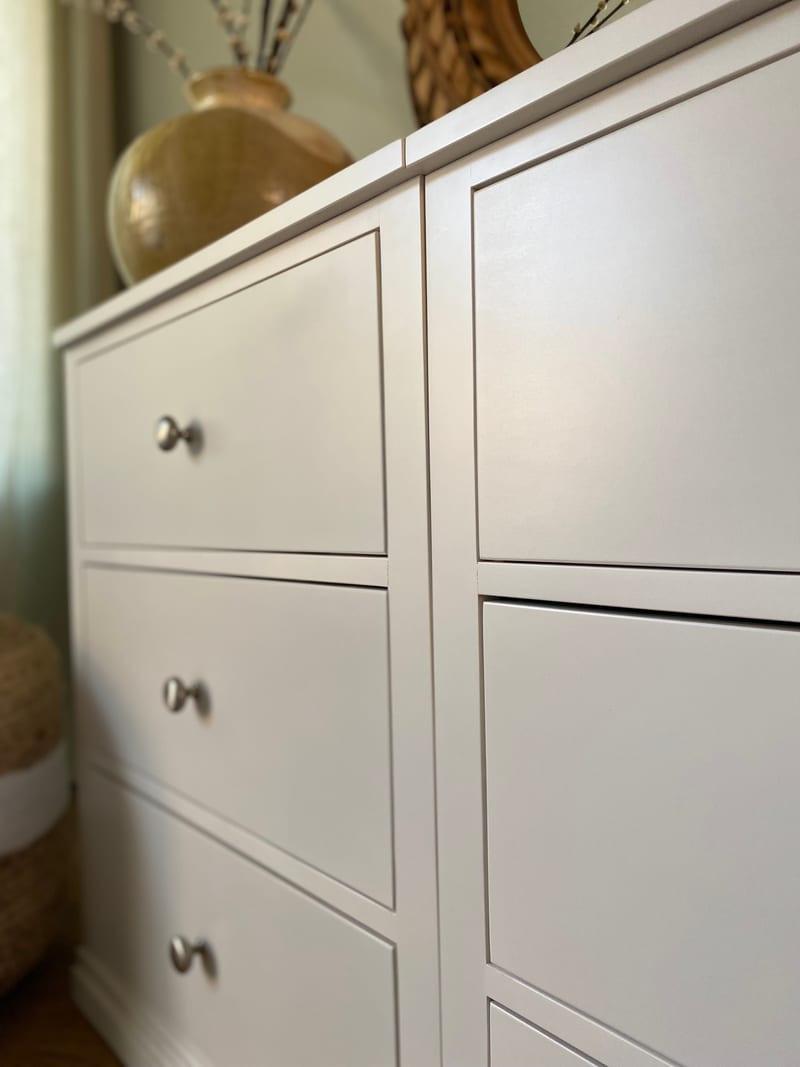 Tight close-up of the two chest modules meeting, showing the crisp painted edges, the recessed drawer fronts and three brushed nickel knobs on the left-hand bank