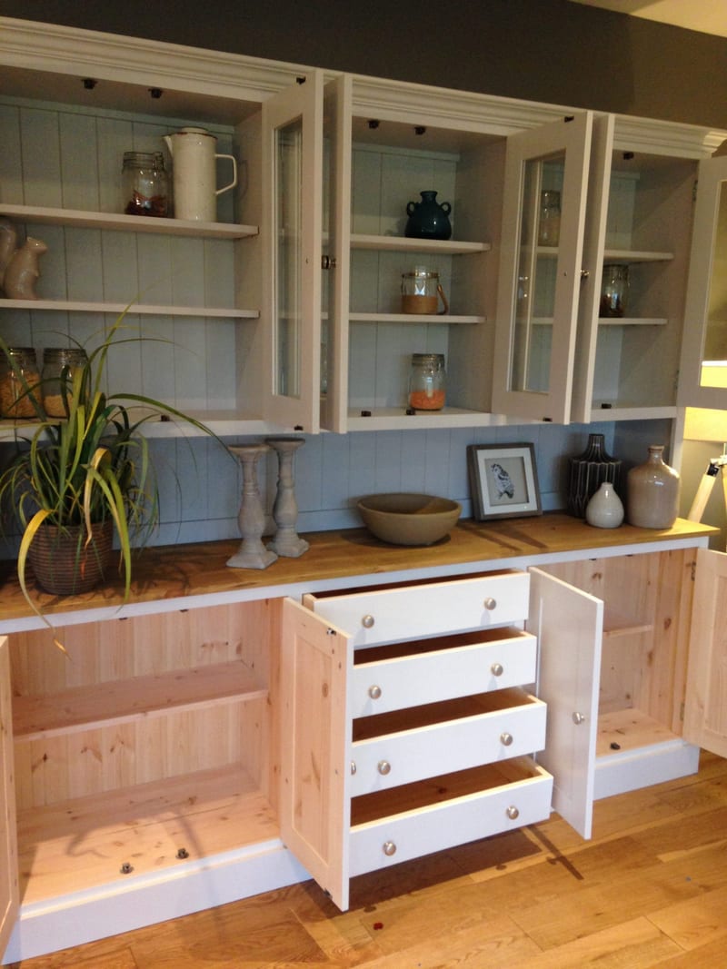 Angled view of the dresser with the base cupboards open and all four drawers pulled out, showing the bare pine carcass interiors, white drawer boxes and brushed nickel knobs