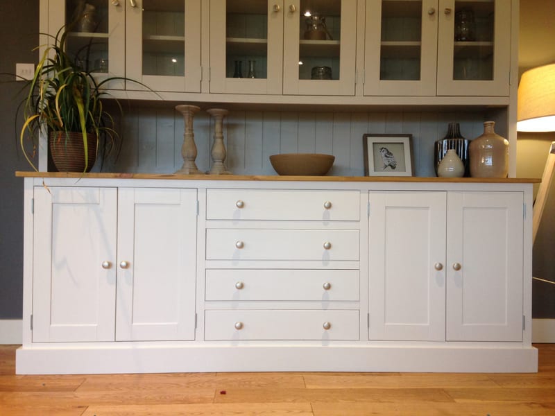 Front view of the dresser base below the glazed rack, showing four shaker doors, four drawers with brushed nickel knobs and the pine top set with candlesticks, a bowl and a framed bird print