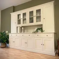 Cream painted 8ft Radwell Welsh dresser with glazed centre doors flanked by tall solid doors, above an oak worktop with drawers and cupboards, against an olive green wall