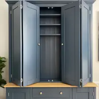 Front view with the bifolding doors folded back, showing the tongue-and-groove lined interior, three adjustable shelves and small spotlights above the oak worktop