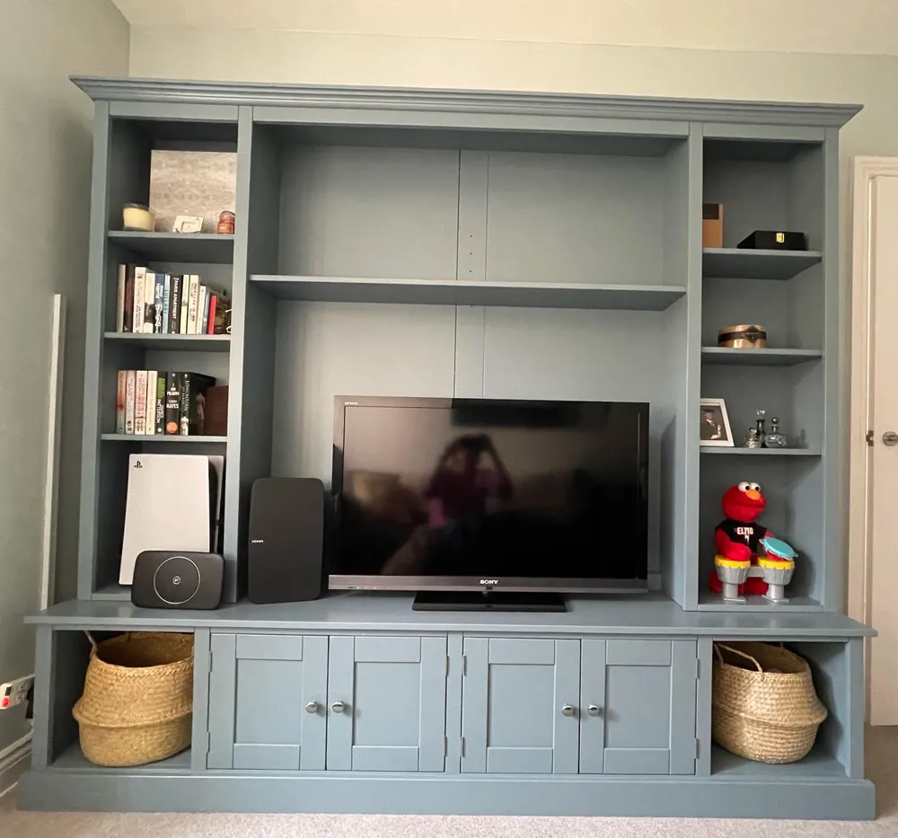 Blue-grey media unit with open shelving, cupboards and a television