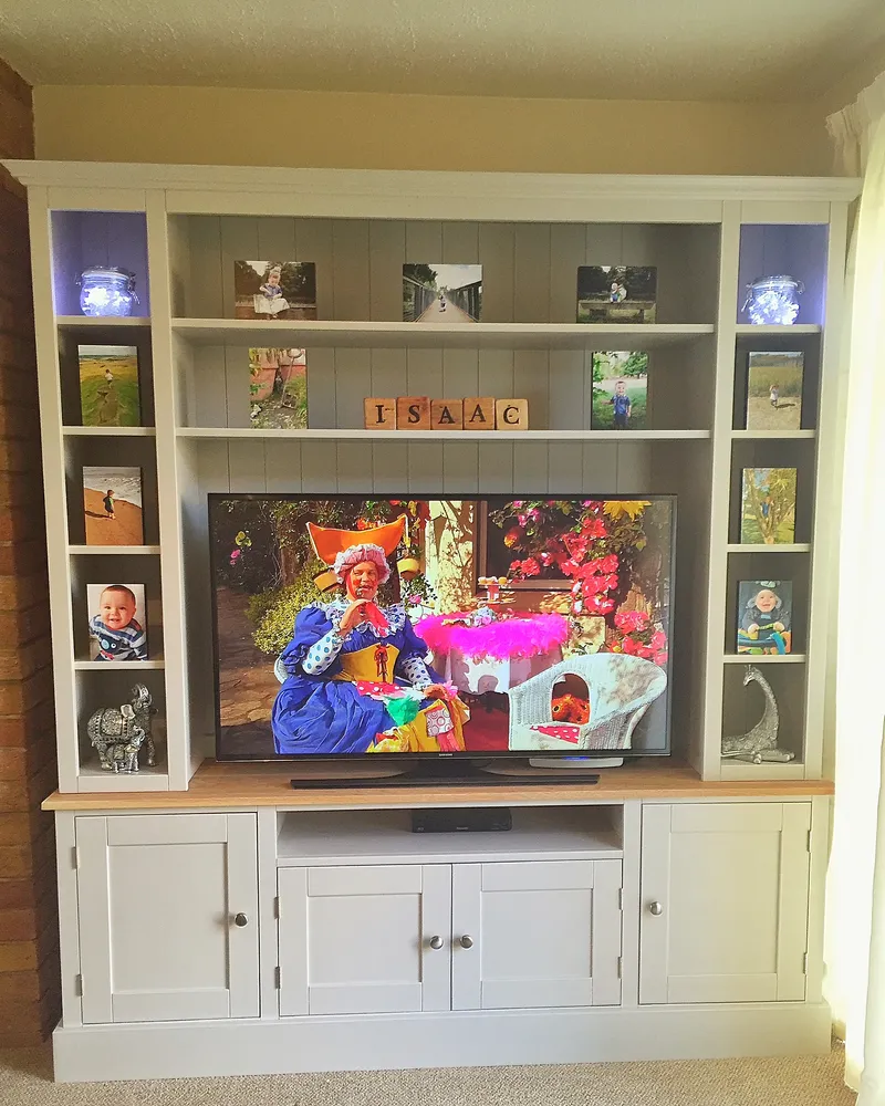 Cream painted media unit with tall open shelving either side and an oak top
