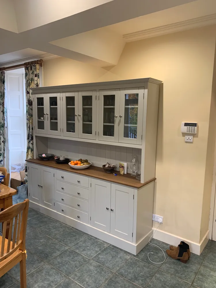 Grey painted kitchen dresser with glazed doors, drawers and an oak top